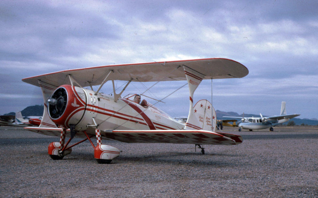 Great Lakes Biplane with engine running on the tarmac at an air show.